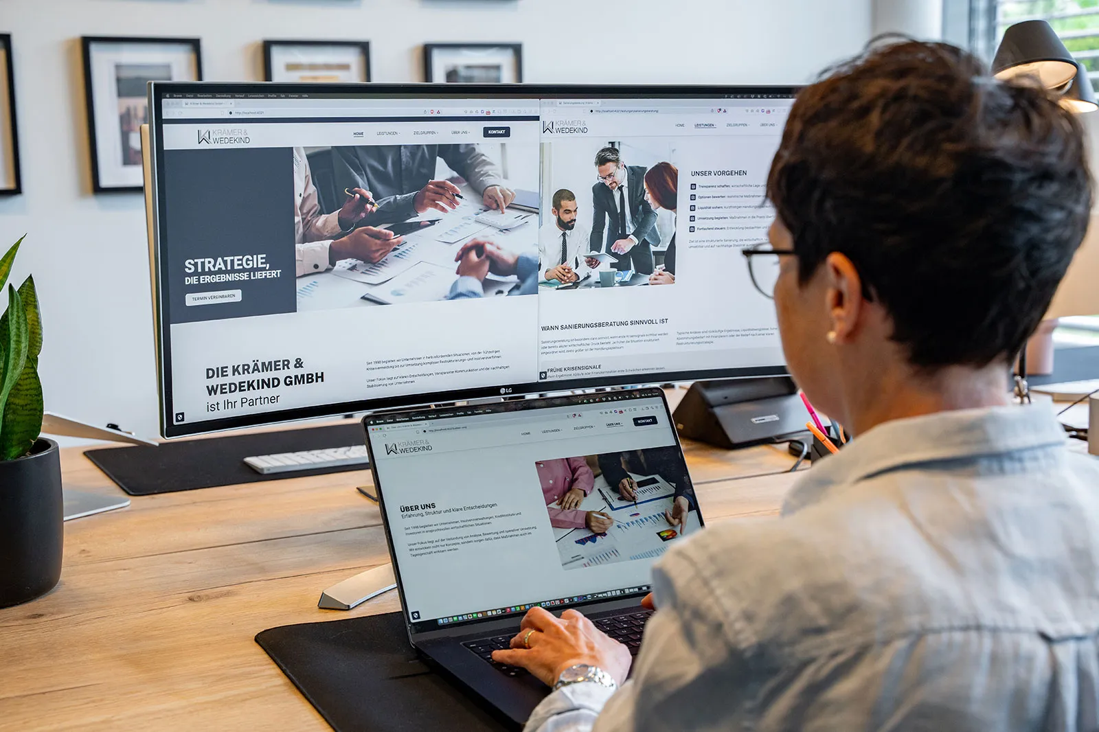 Mitarbeiterin am Schreibtisch mit der Krämer & Wedekind Website auf dem Bildschirm