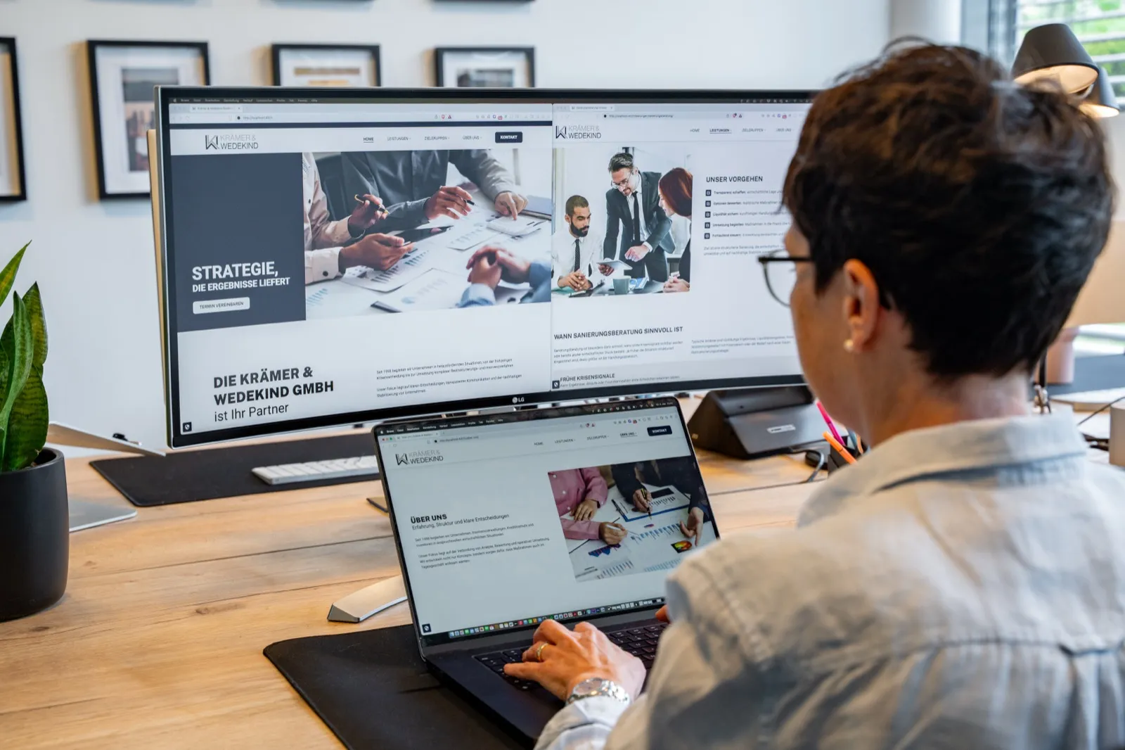 Mitarbeiterin am Schreibtisch mit der Krämer & Wedekind Website auf dem Bildschirm