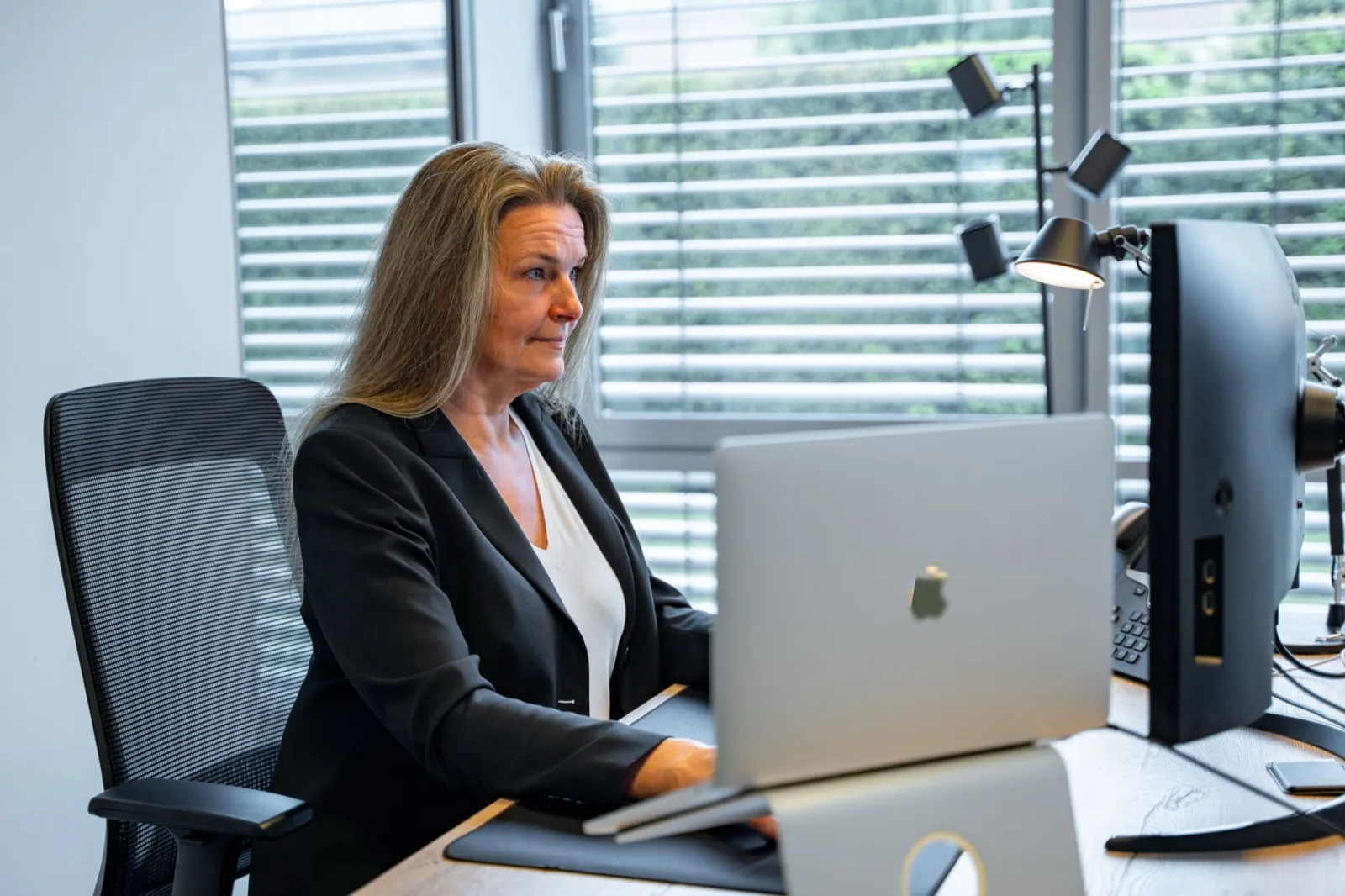 Ute Wedekind arbeitet konzentriert am Laptop im Büro